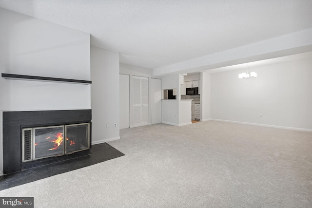 unfurnished living room with dark colored carpet, a multi sided fireplace, and a chandelier