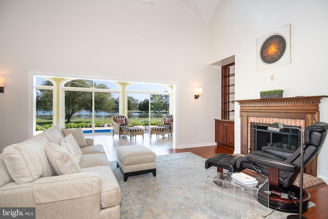 living room with wood-type flooring, a fireplace, and high vaulted ceiling