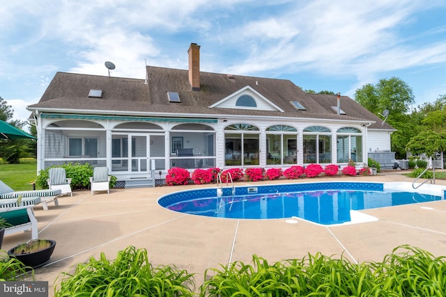 rear view of house featuring a patio area and a sunroom