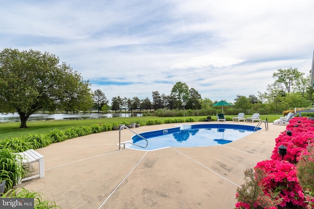 view of pool featuring a patio area and a water view