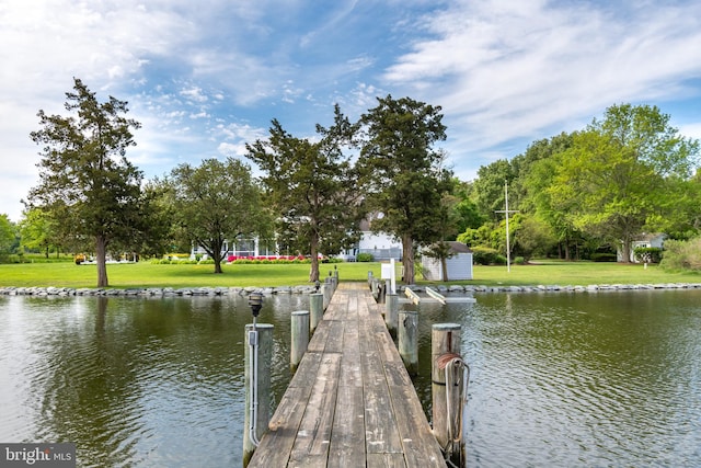 dock area with a yard and a water view