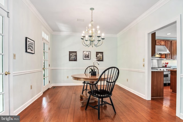 dining space featuring an inviting chandelier, wood-type flooring, and crown molding