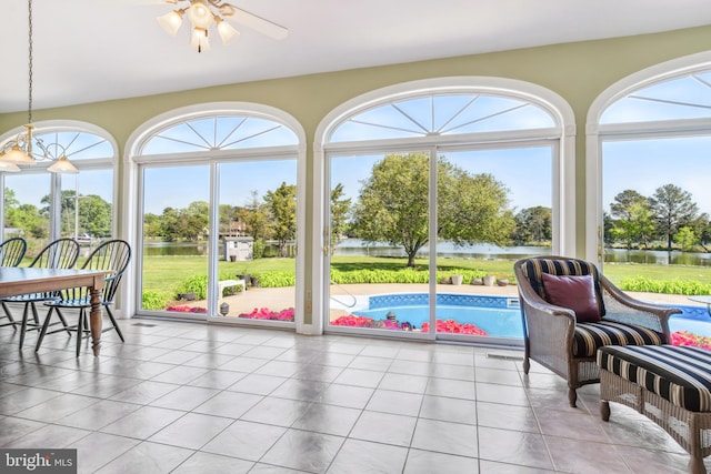 sunroom with a water view, a healthy amount of sunlight, and ceiling fan