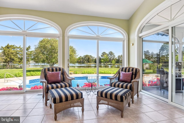 sunroom featuring a water view