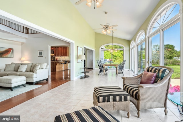 sunroom featuring sink, vaulted ceiling, and ceiling fan with notable chandelier