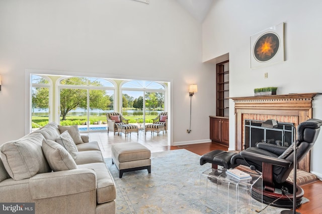 living room featuring a towering ceiling, hardwood / wood-style floors, and a fireplace