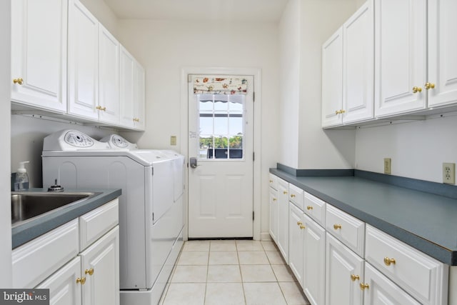 washroom with cabinets, sink, washer and clothes dryer, and light tile patterned floors