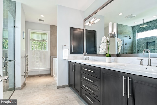 bathroom featuring vanity, tile patterned flooring, and tiled shower