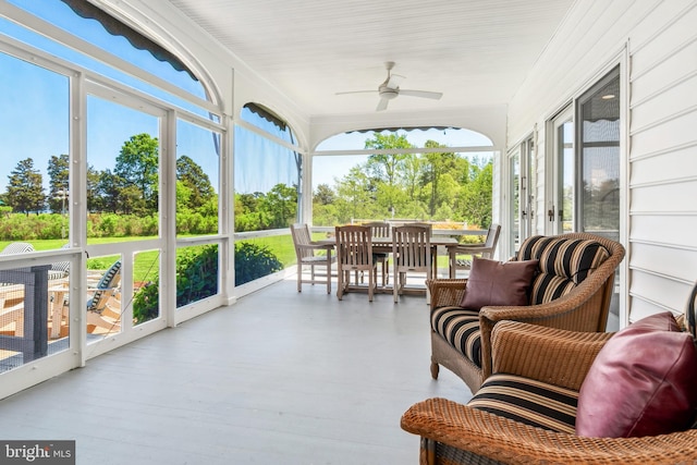 sunroom featuring ceiling fan and plenty of natural light