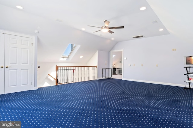 additional living space featuring lofted ceiling with skylight, carpet, and ceiling fan