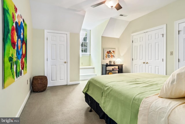 bedroom featuring lofted ceiling, multiple closets, carpet flooring, and ceiling fan