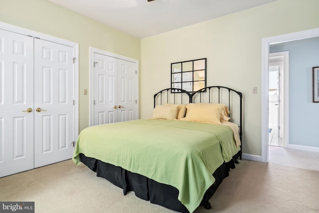 carpeted bedroom with multiple closets and multiple windows