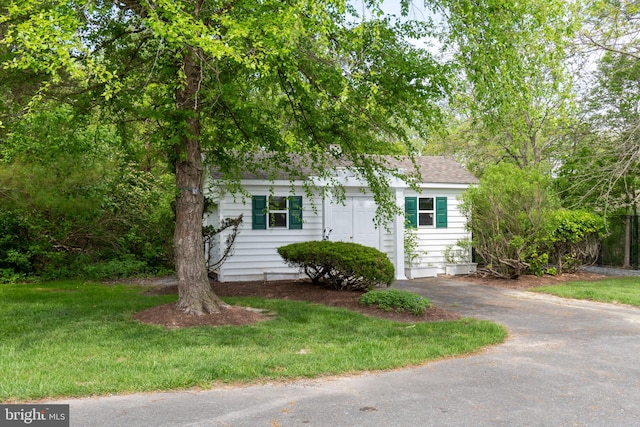 view of property hidden behind natural elements featuring a front yard