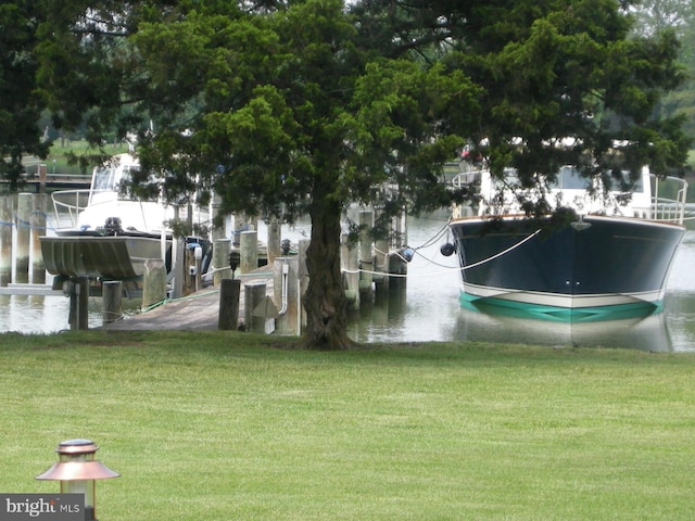 surrounding community featuring a water view, a dock, and a lawn