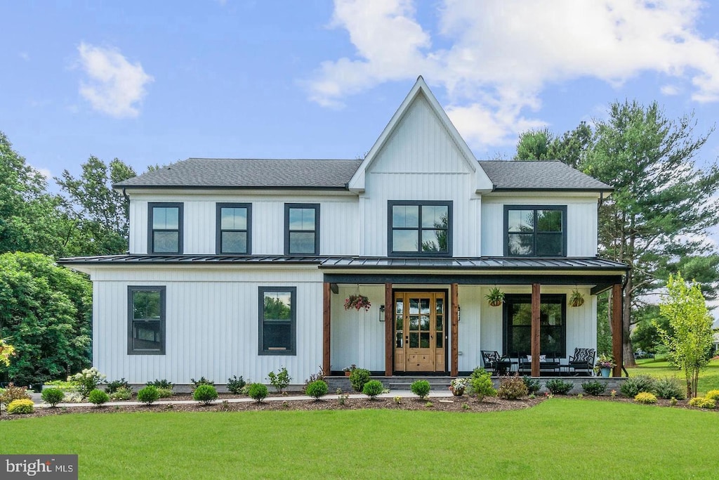 modern farmhouse with a front lawn and a porch