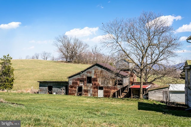 exterior space with an outbuilding, a yard, and a rural view