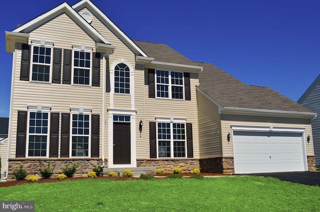 view of front of property featuring a front yard and a garage