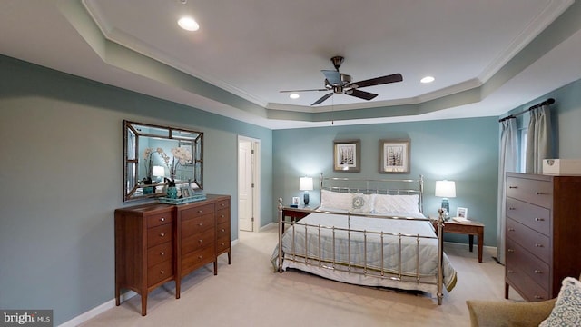 bedroom featuring light carpet, ceiling fan, crown molding, and a tray ceiling