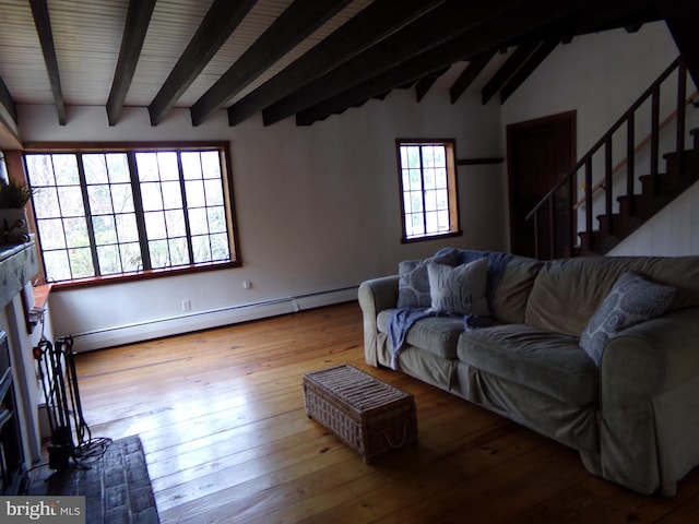 living room with baseboard heating, vaulted ceiling with beams, a wealth of natural light, and light hardwood / wood-style floors