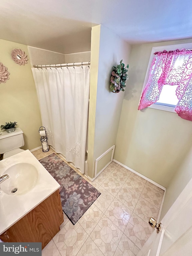 bathroom featuring tile flooring, toilet, and vanity