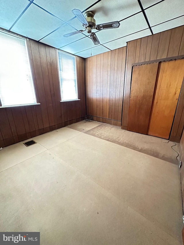 spare room featuring wood walls and ceiling fan