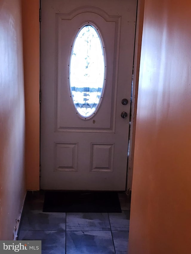 entryway featuring dark tile floors