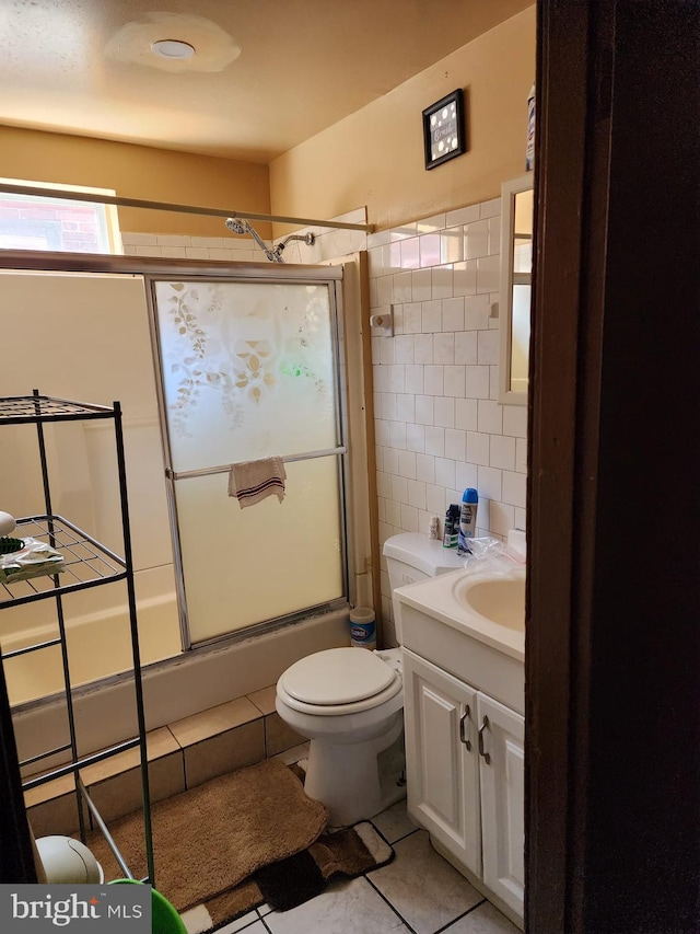 bathroom with vanity, toilet, tile flooring, and tile walls