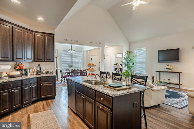 kitchen featuring wood-type flooring, sink, ceiling fan with notable chandelier, and light stone countertops