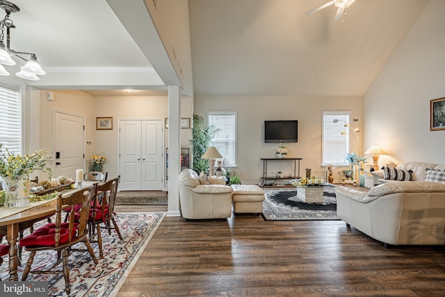 living room with dark hardwood / wood-style flooring, ceiling fan, and vaulted ceiling