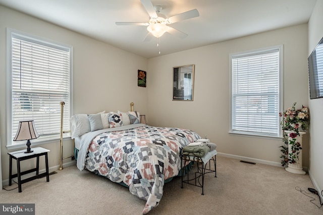 carpeted bedroom with multiple windows and ceiling fan