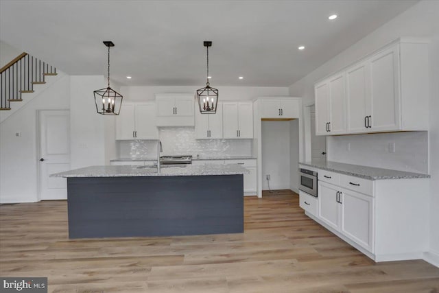 kitchen featuring pendant lighting, white cabinetry, and light hardwood / wood-style flooring