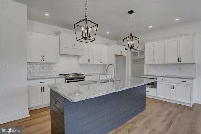 kitchen with light hardwood / wood-style floors, gas range, pendant lighting, and white cabinetry