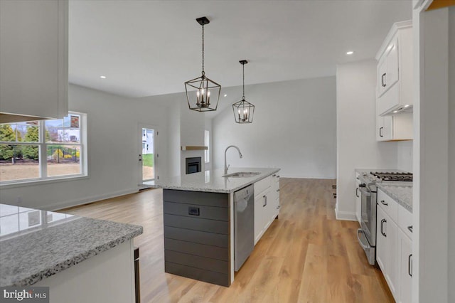 kitchen featuring white cabinets, light hardwood / wood-style flooring, an island with sink, and pendant lighting