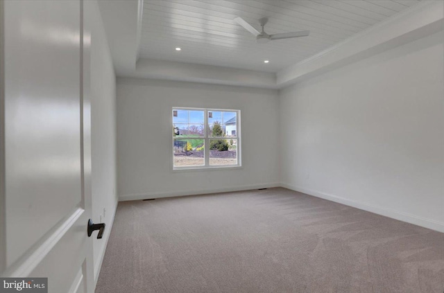 unfurnished room with ceiling fan, light colored carpet, and a raised ceiling