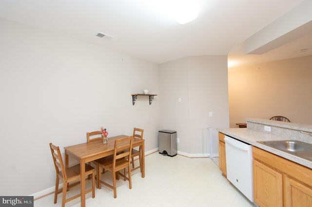 kitchen with sink, dishwasher, light tile floors, and light brown cabinetry