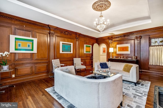 living room featuring a notable chandelier, dark hardwood / wood-style flooring, and a raised ceiling