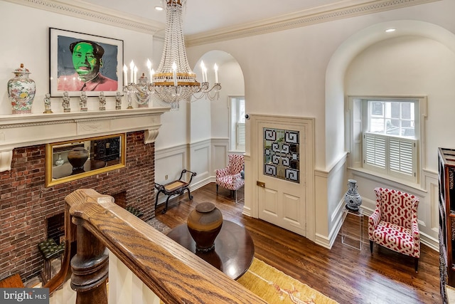 sitting room featuring dark hardwood / wood-style flooring, crown molding, and an inviting chandelier