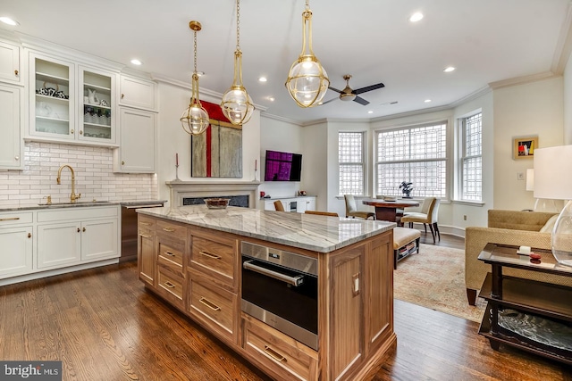 kitchen featuring light stone counters, stainless steel appliances, dark hardwood / wood-style flooring, sink, and white cabinets