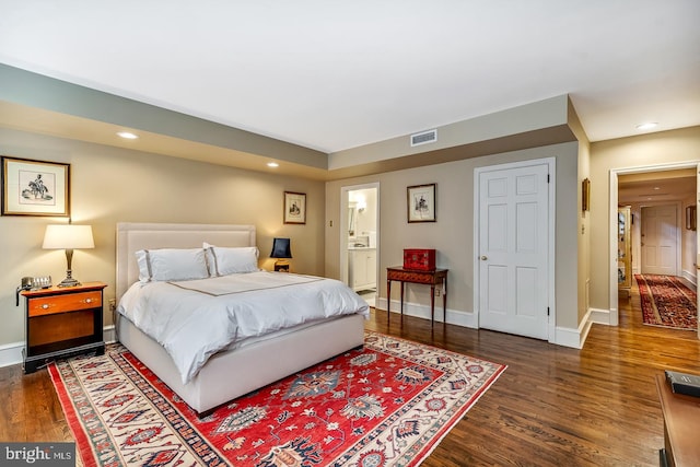 bedroom featuring connected bathroom and dark hardwood / wood-style floors