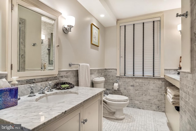 bathroom with toilet, large vanity, tile floors, tile walls, and tasteful backsplash