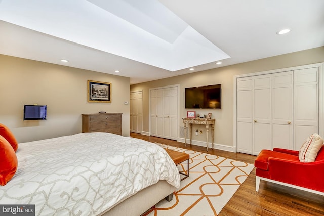 bedroom featuring two closets and light hardwood / wood-style floors