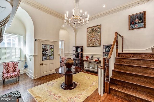 foyer entrance featuring a notable chandelier, dark wood-type flooring, and ornamental molding