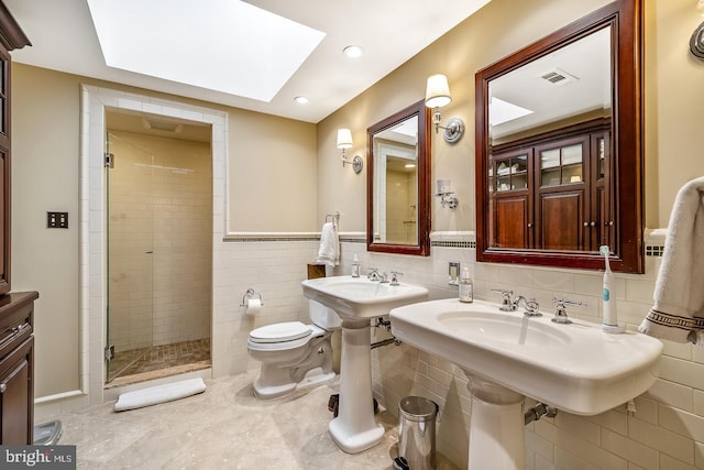 bathroom featuring toilet, a skylight, tile walls, tiled shower, and tasteful backsplash