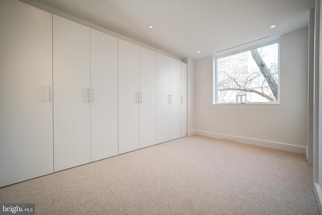 unfurnished bedroom featuring light carpet