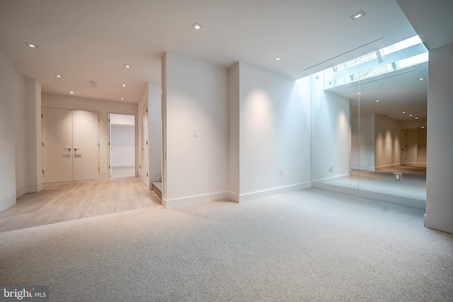 carpeted empty room featuring a skylight