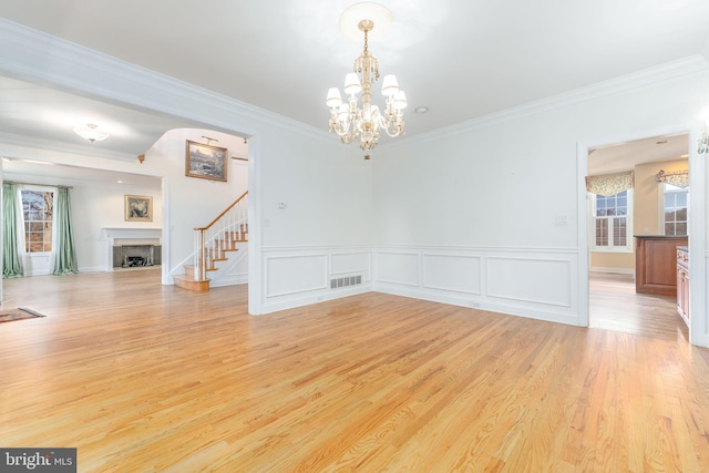 interior space with crown molding, light hardwood / wood-style floors, and an inviting chandelier