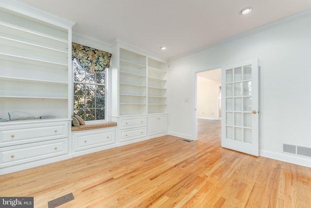 interior space featuring built in features, ornamental molding, and light wood-type flooring