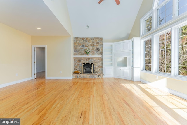 unfurnished living room featuring a fireplace, ceiling fan, light hardwood / wood-style flooring, and high vaulted ceiling