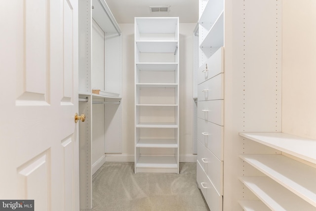 walk in closet featuring light colored carpet