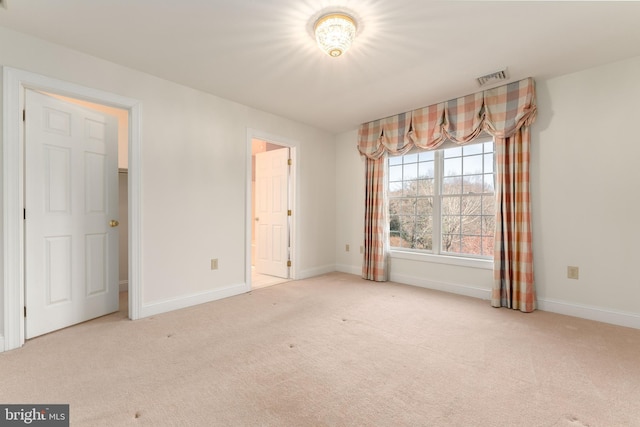 spare room featuring light carpet